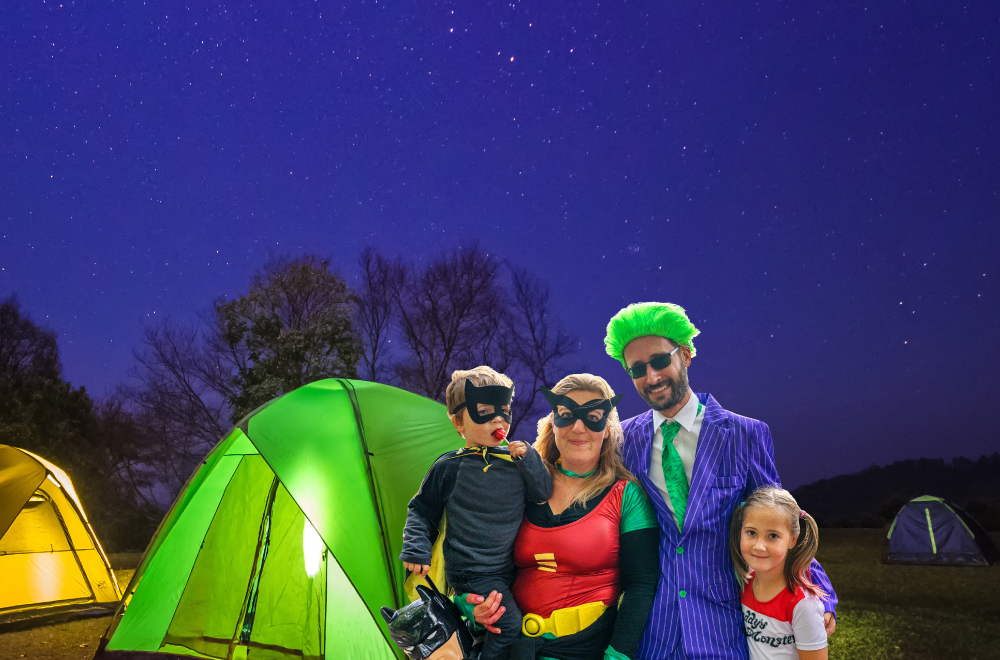 Family with Halloween costumes next to a tent