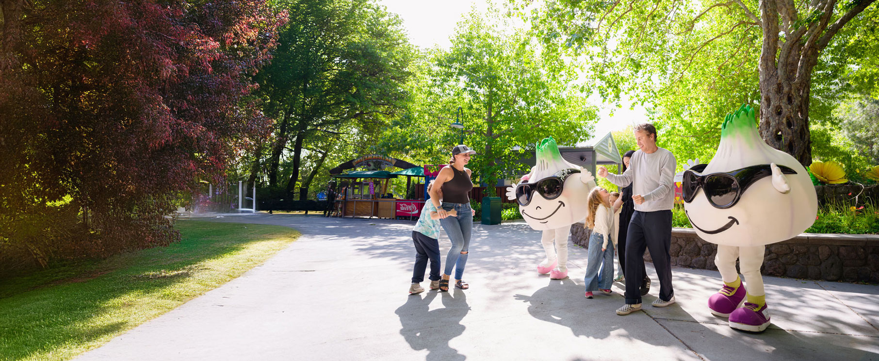 Families dancing with Gil and Roy in front of circus trees and other large trees