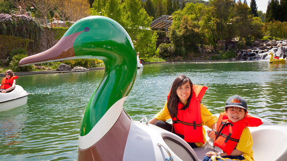 Mother and son in orange life jackets smiling while on the Paddle Boats on Coyote Lake