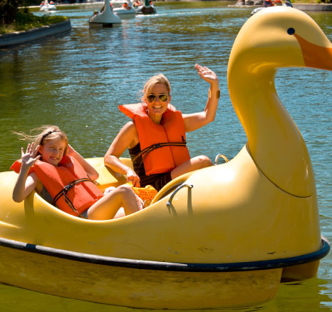 Mother and daughter in orange life jackets waving while on the Paddle Boats on Coyote Lake