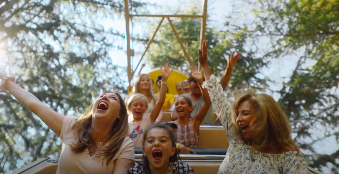 Guests smiling and laughing with their hands in the air on the Banana Split ride