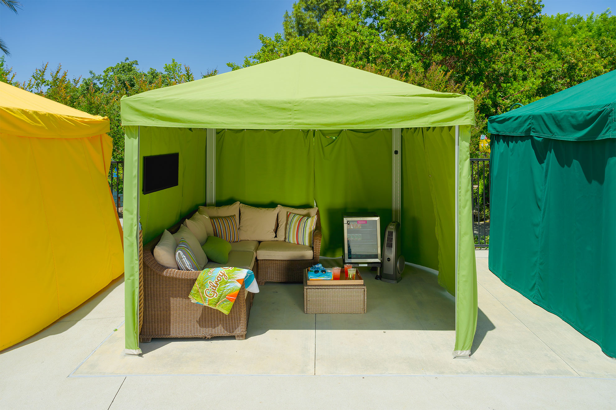Luxury green cabana with TV, fan and refrigerator inside
