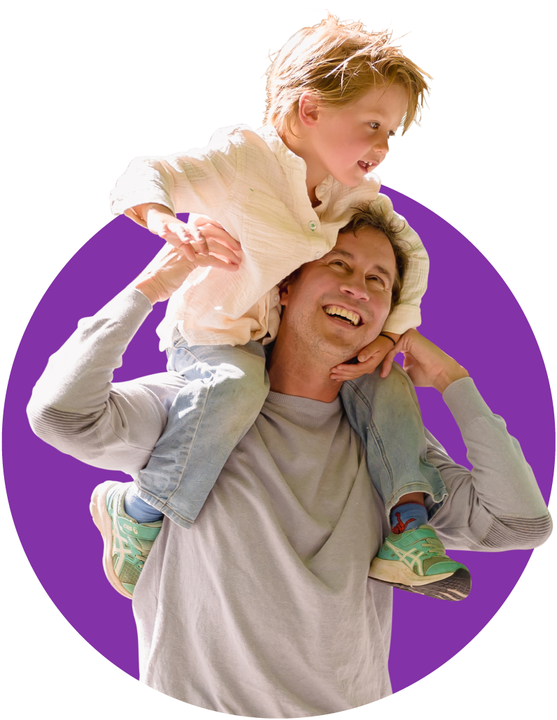 Father in grey long sleeve and black pants holding his son in a white shirt on his shoulders