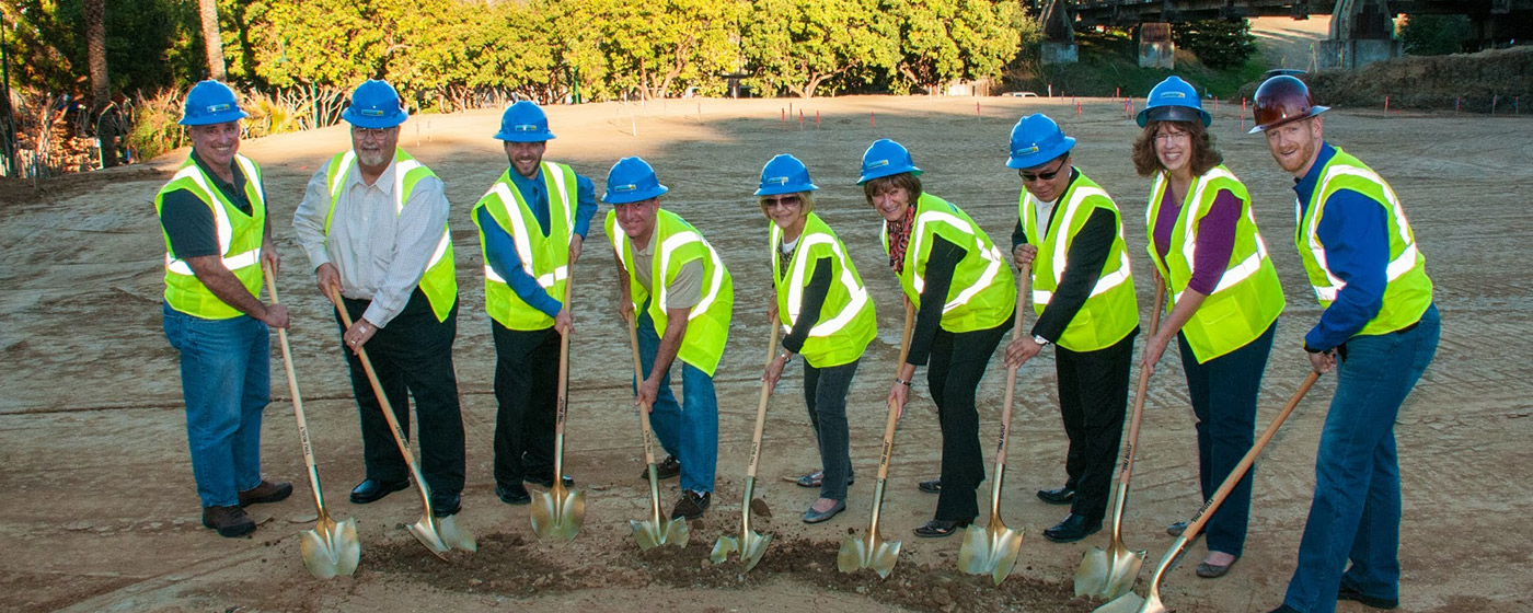 Women and men breaking ground at a new development while smiling
