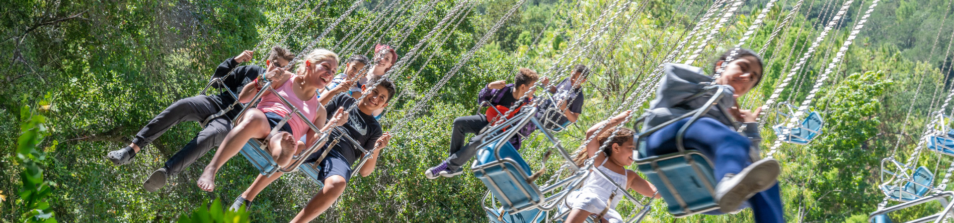 Many children smiling while on the Mushroom Swing ride