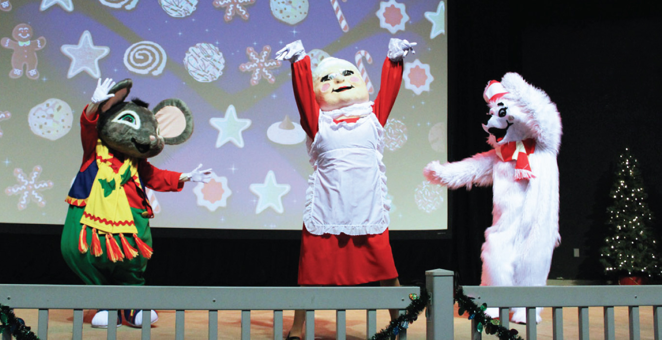 Rudy the Polar Bear dancing with Mrs. Claus and Skitter the Mouse on stage.
