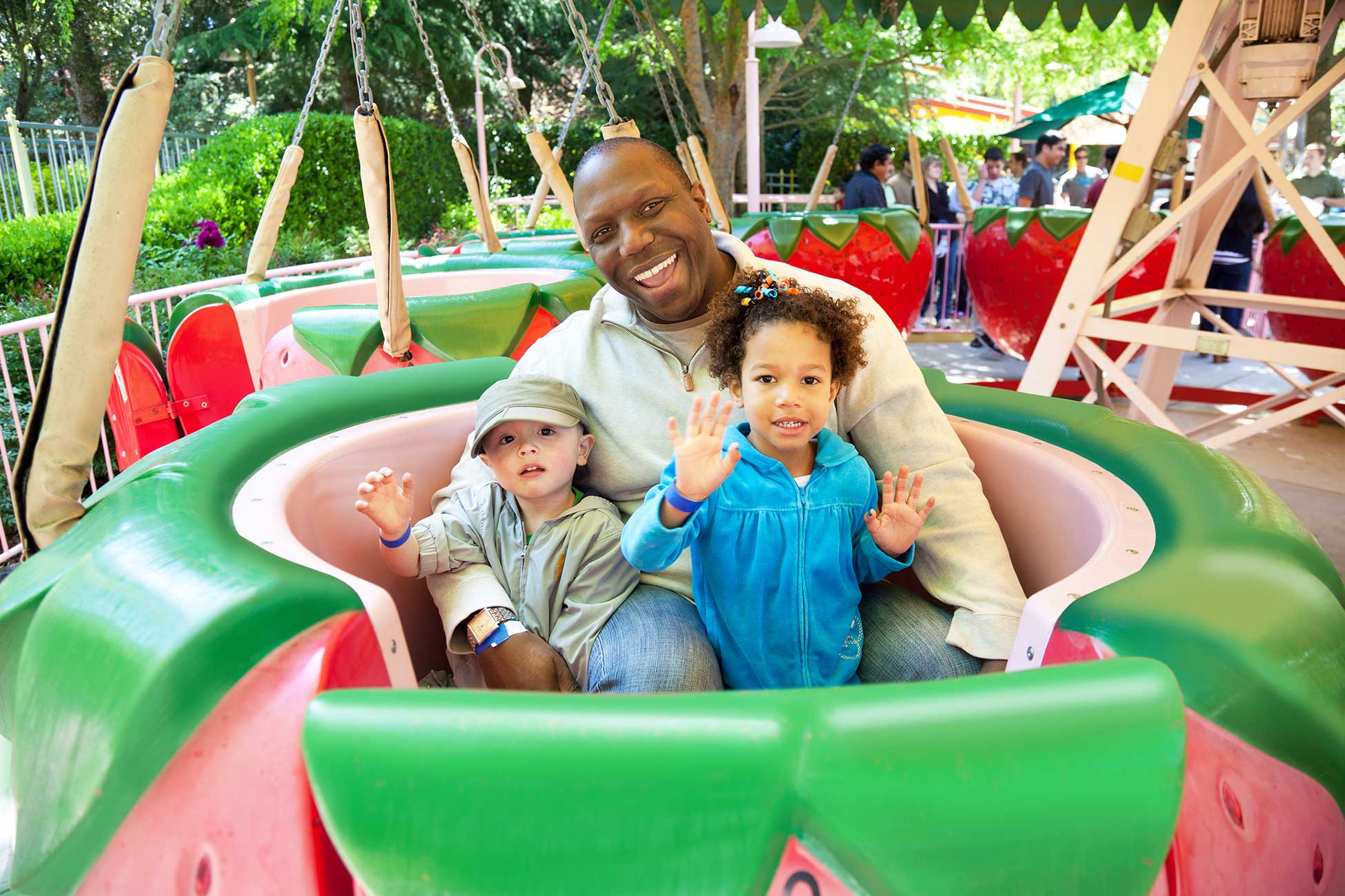 Dad with his son and daughter smiling on the Strawberry Sundae ride
