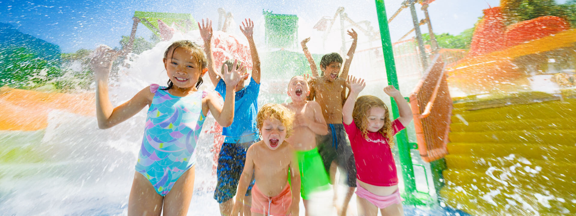 Children smiling and screaming with joy as the Brave the Bucket spills water all over them.