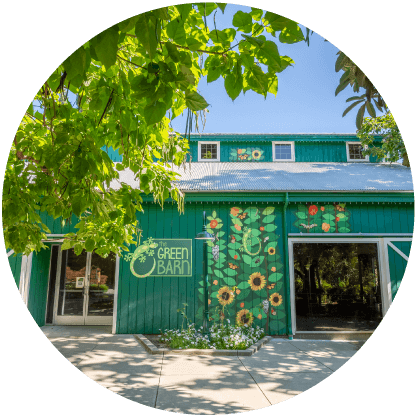 The Green Barn building with sunflowers and leaves on the outside.
