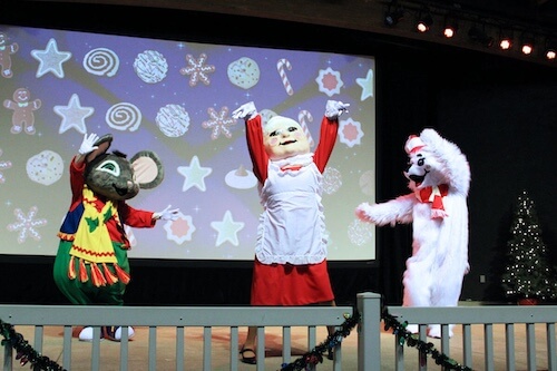 Rudy the Polar Bear dancing with Mrs. Claus and Skitter the Mouse on stage.