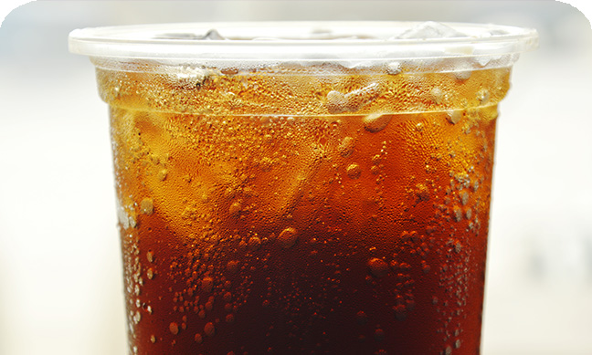 Ice cold soda in a clear plastic cup