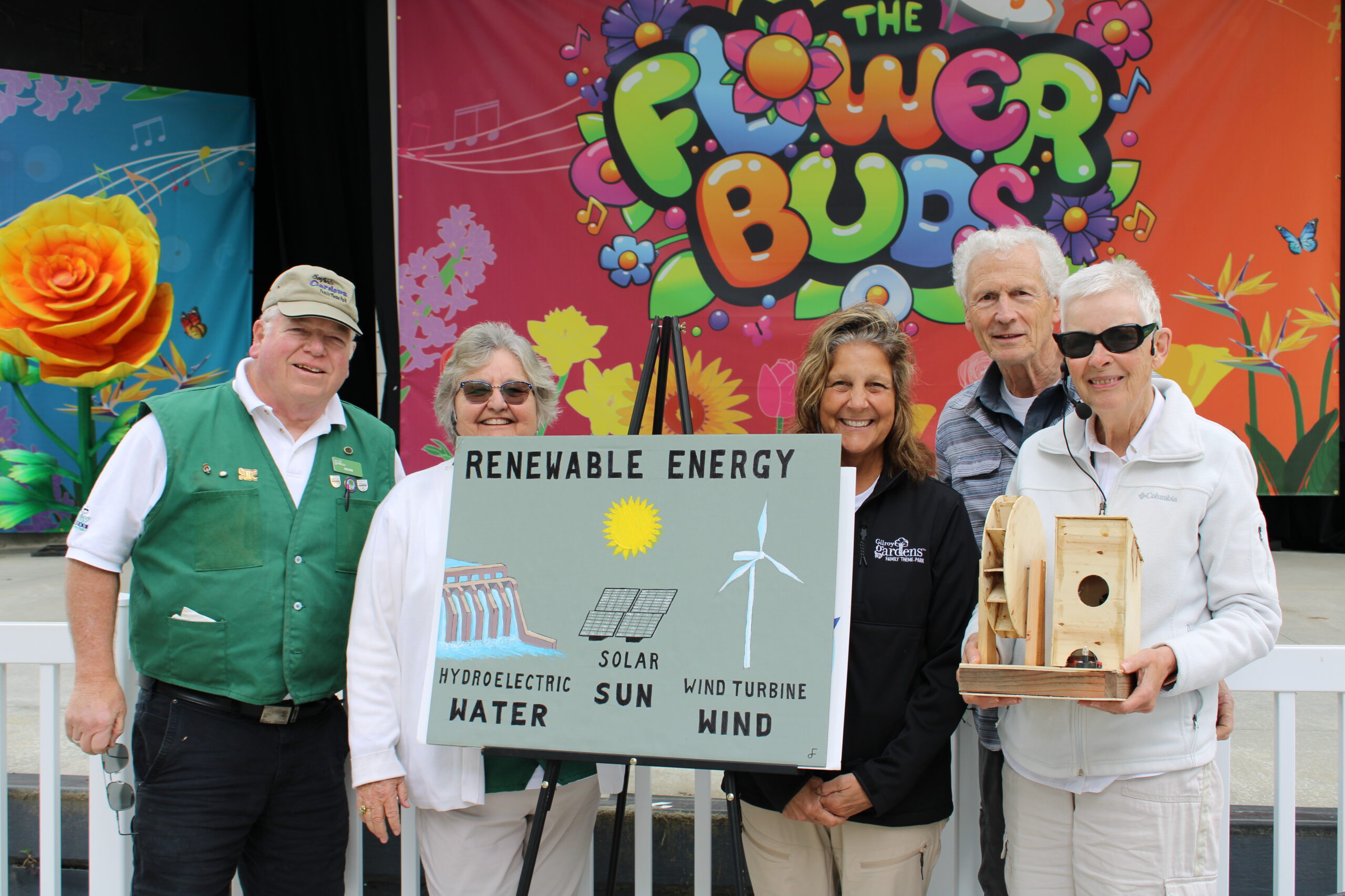 5 docents standing beside a solar energy sign.