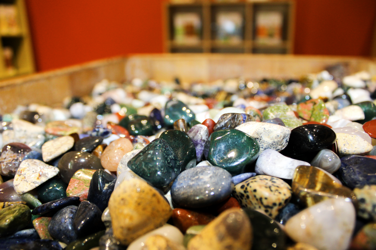 A pile of rocks in varies colors such as green, brown, white, yellow with black polka dots, red, and black.