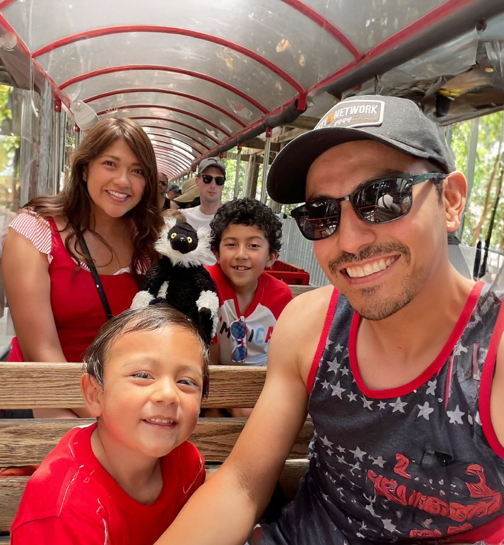 Family of four in patriotic attire smiling while on the Coyote & Redwood Railroad ride at the Memorial Day Celebration