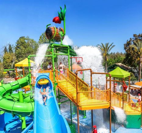 Boy smiling while going down a blue water slide