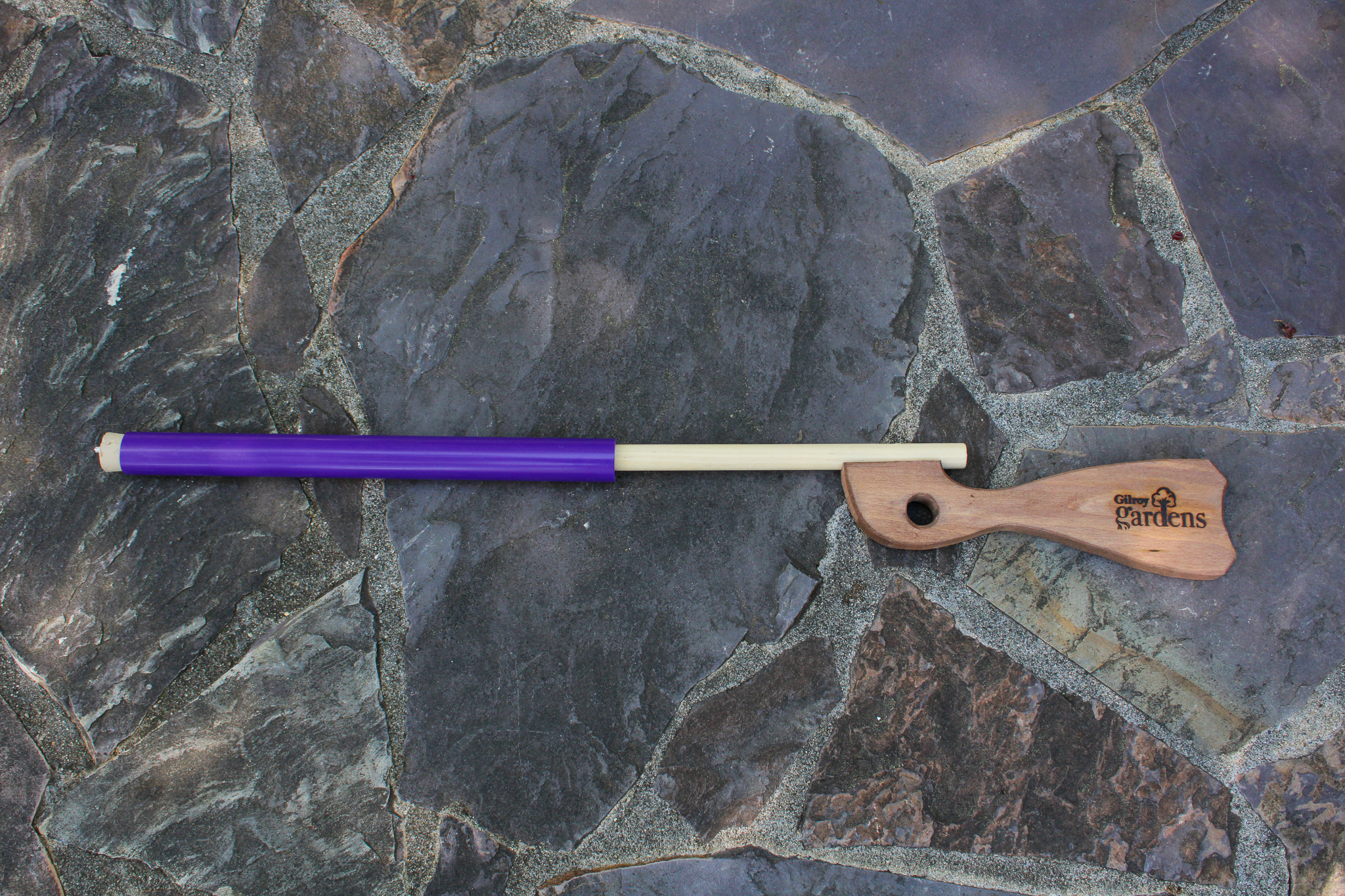 Purple wooden gun on grey rock