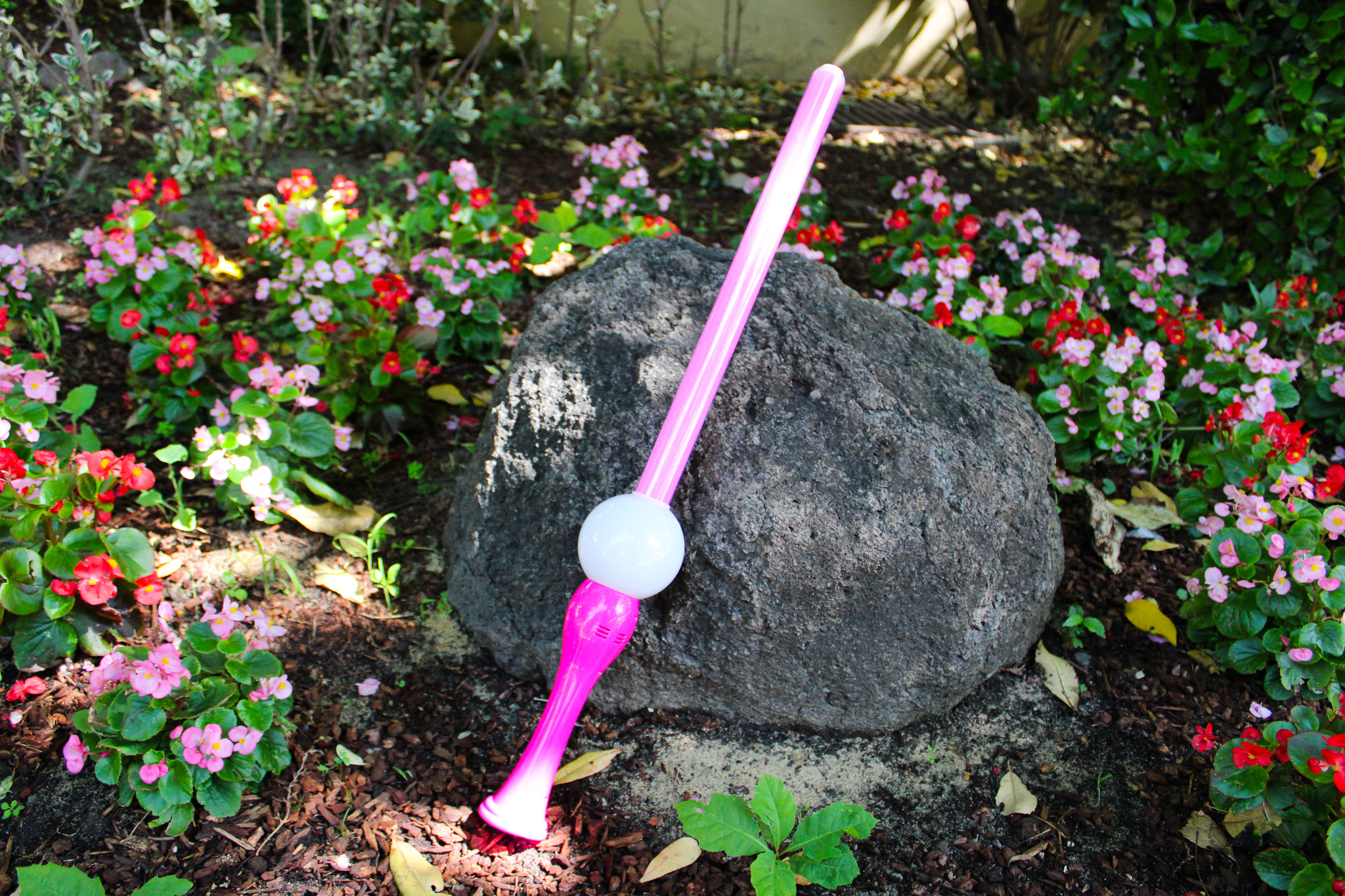 Pink bubble wand up against a large grey rock