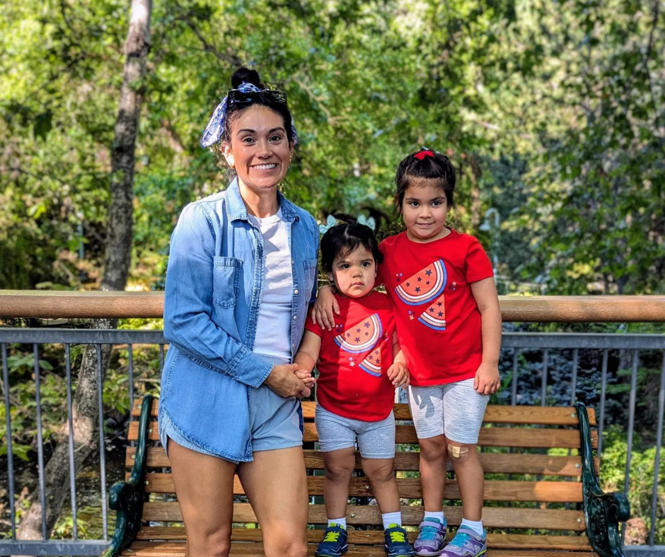 Mother with her two daughters smiling on Sycamore Bridge on a bench