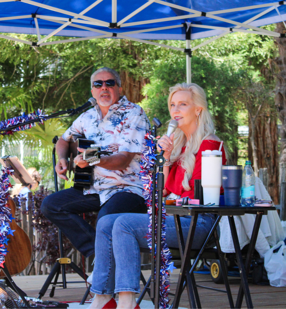 Woman siting while singing and a man playing the guitar