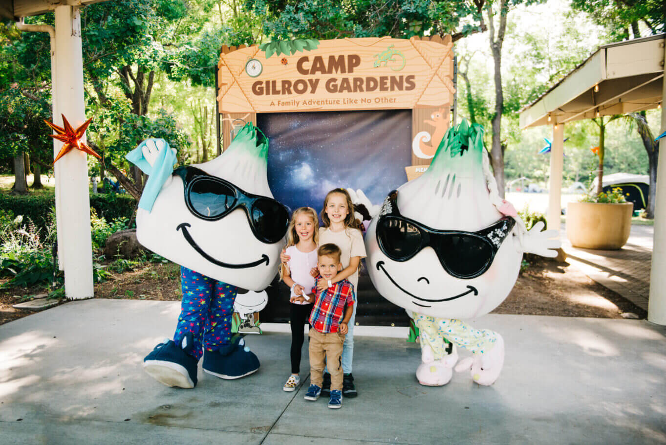 Three children smiling while taking a picture with Gil and Roy