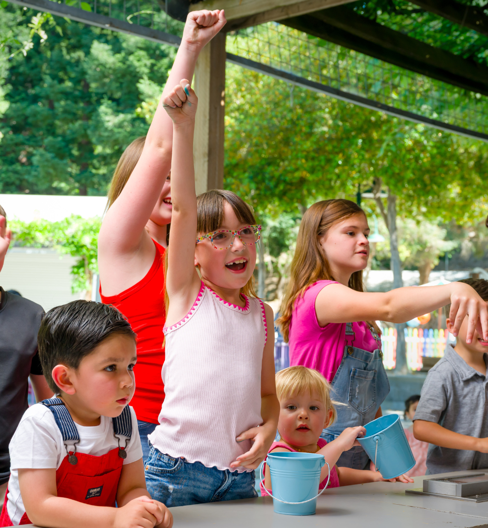 Several children smiling while playing a tossing game.