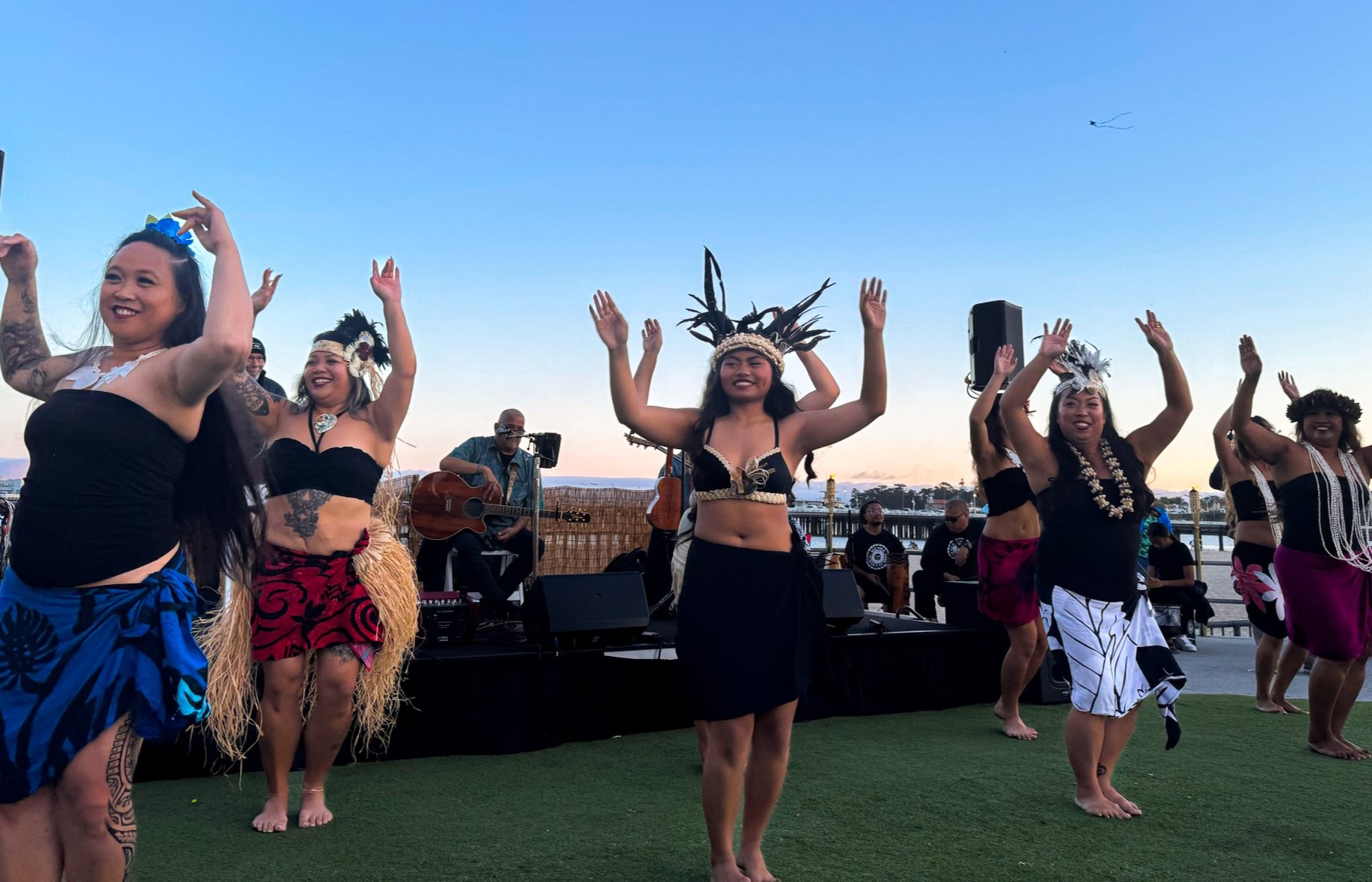 Group of women smiling while performing in a luau